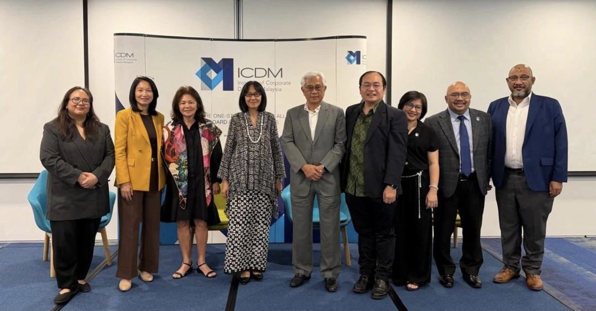 Nine people standing in a line for a group photograph in front of the ICDM — Institute of Corporate Directors Malaysia — backdrop, in a meeting room with a blue carpet. Reza Ali stands sixth from the left, in a green patterned shirt and a dark blazer.